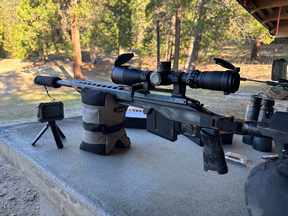 Fierce rifle with suppressor and scope resting on a shooting bag at an outdoor range